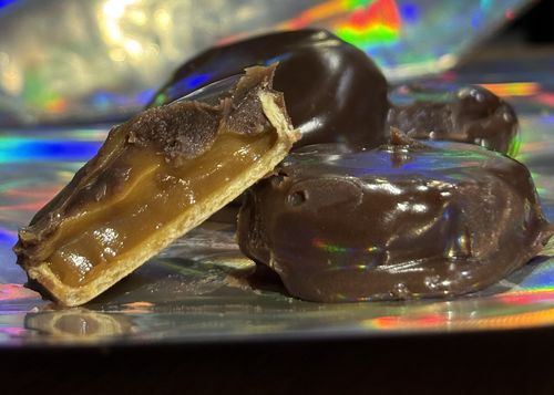 Bombón elaborado con cacao al 70% relleno con dulce de leche y ron.
